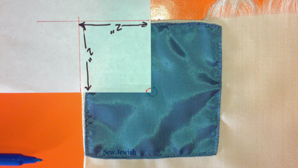 Where to put tzitzit hole on tallit