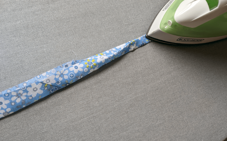 Fold and press fabric strip to make double folded string.